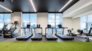 A gym with treadmills, exercise bikes, and weights. - NEW | High-Rise 1BR Den, Rooftop Pool & Gym 402 (Miami)