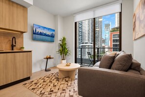 Eine moderne Wohnung mit Küche, Essbereich und Wohnzimmer mit großem Fenster und Blick auf die Stadt.