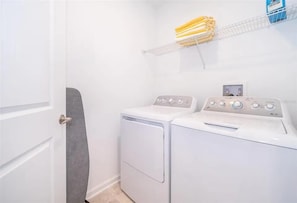 Convenient laundry room with full-size washer and dryer, crisp white finishes, and handy shelving for longer stays. - NEW | 2Bd Retreat with Game Room & Lazy River 9333 (Davenport)