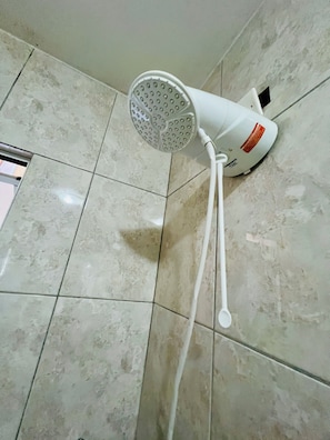 A white handheld showerhead mounted on a tiled wall. - Pink Room near PUC Arena da Baixada, botanical garden and downtown Curitiba. (Curitiba)