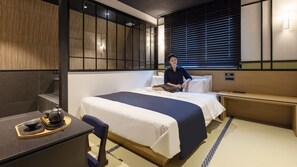Une chambre d’hôtel équipée d’un lit, d’une table de chevet et d’un bureau avec une bouilloire.