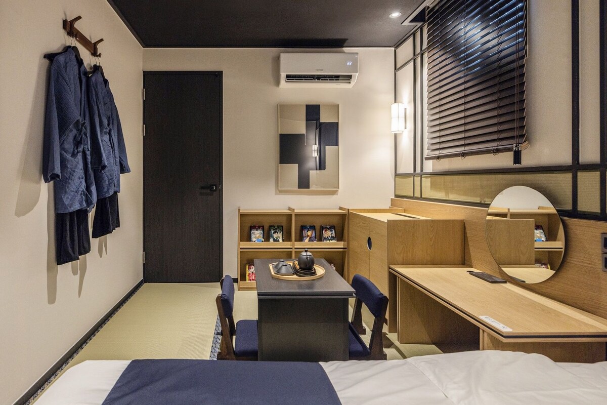 Une chambre d’hôtel comprenant un lit, un bureau, une chaise, une armoire et un miroir.