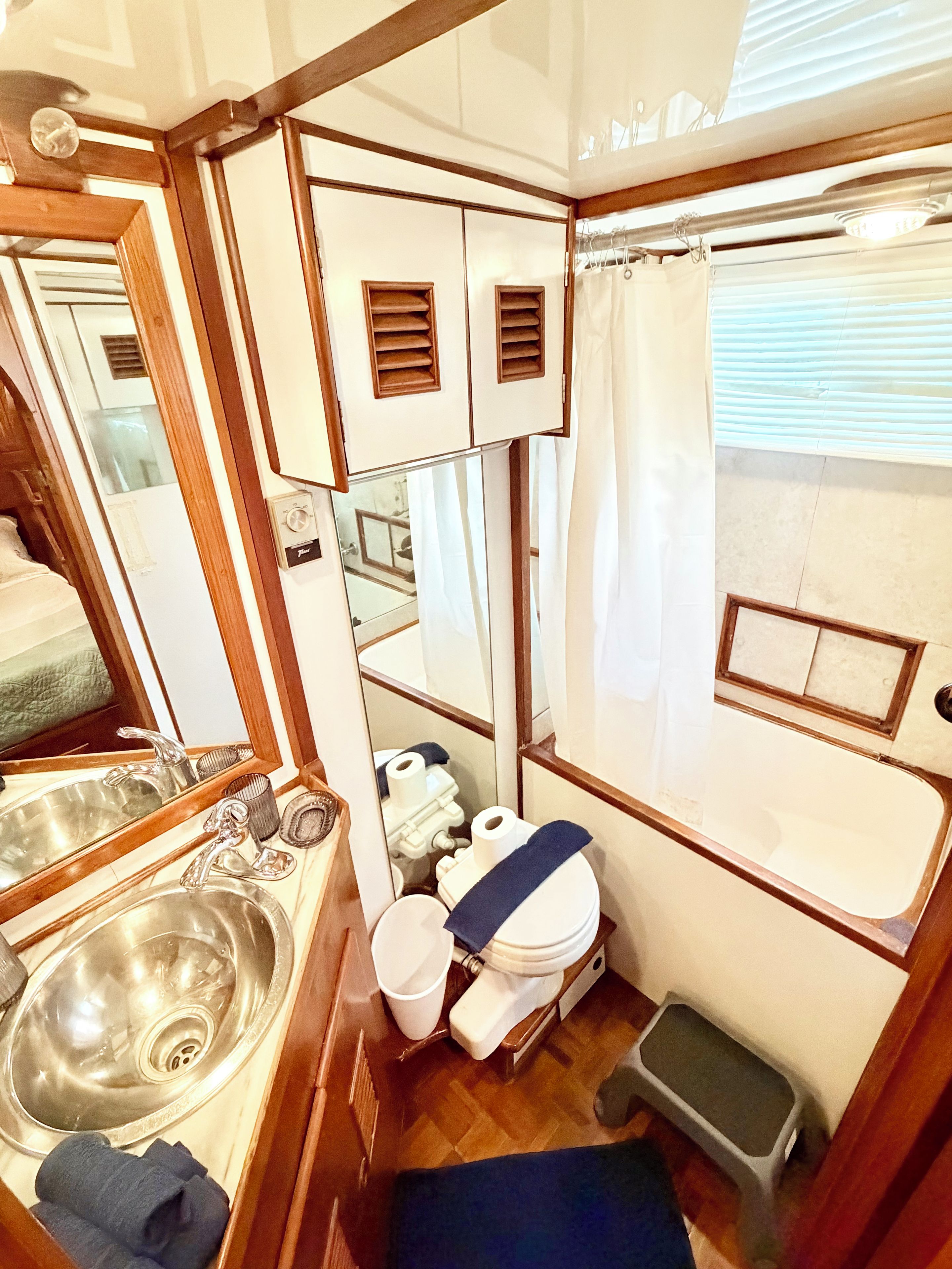 A compact RV bathroom with a sink, toilet, and shower area.