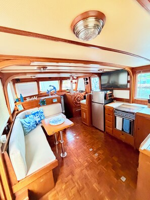 Une cuisine de taille réduite, équipée d’une cuisinière, d’un réfrigérateur et de meubles de rangement en bois.