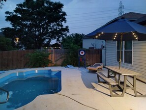 A backyard with a swimming pool, a wooden deck, lounge chairs, and an umbrella. - Cozy San Riveria Pool property near Sea World 3bed 2bath house with fireplace! (San Antonio)