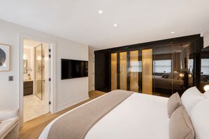 A modern bedroom with a large bed, a TV mounted on the wall, and a sliding glass door leading to a balcony. - Mayfair Duplex Private Terrace AC (London)