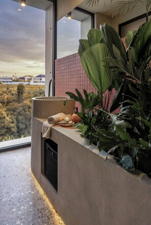 Un baño moderno con un ventanal grande, un lavabo y un perchero para toallas.
