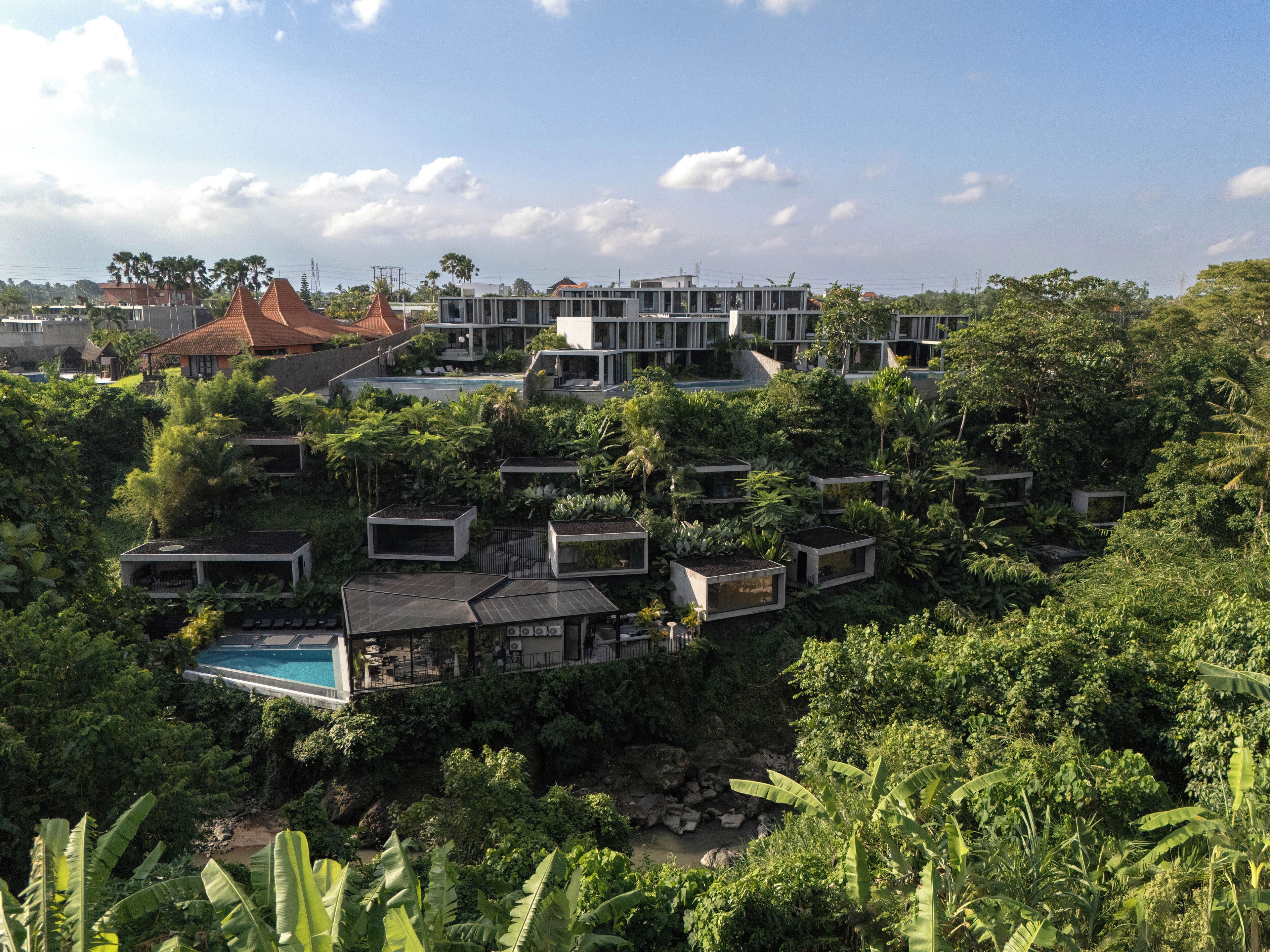 A residential area with modern houses, a swimming pool, and lush greenery.