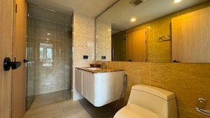 A modern bathroom with a glass shower enclosure, a white toilet, and a vanity with a marble countertop. - Modern 2 Bed, 2 Bath in Bang Tao - Brand New 75sqm at Ozone (Choeng Thale)