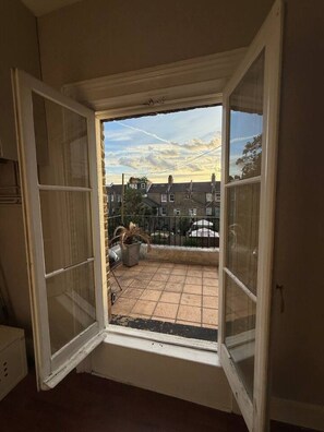 A room with a large window opening to a balcony. - Sunny 2-bed Triplex With Private Terrace (London)