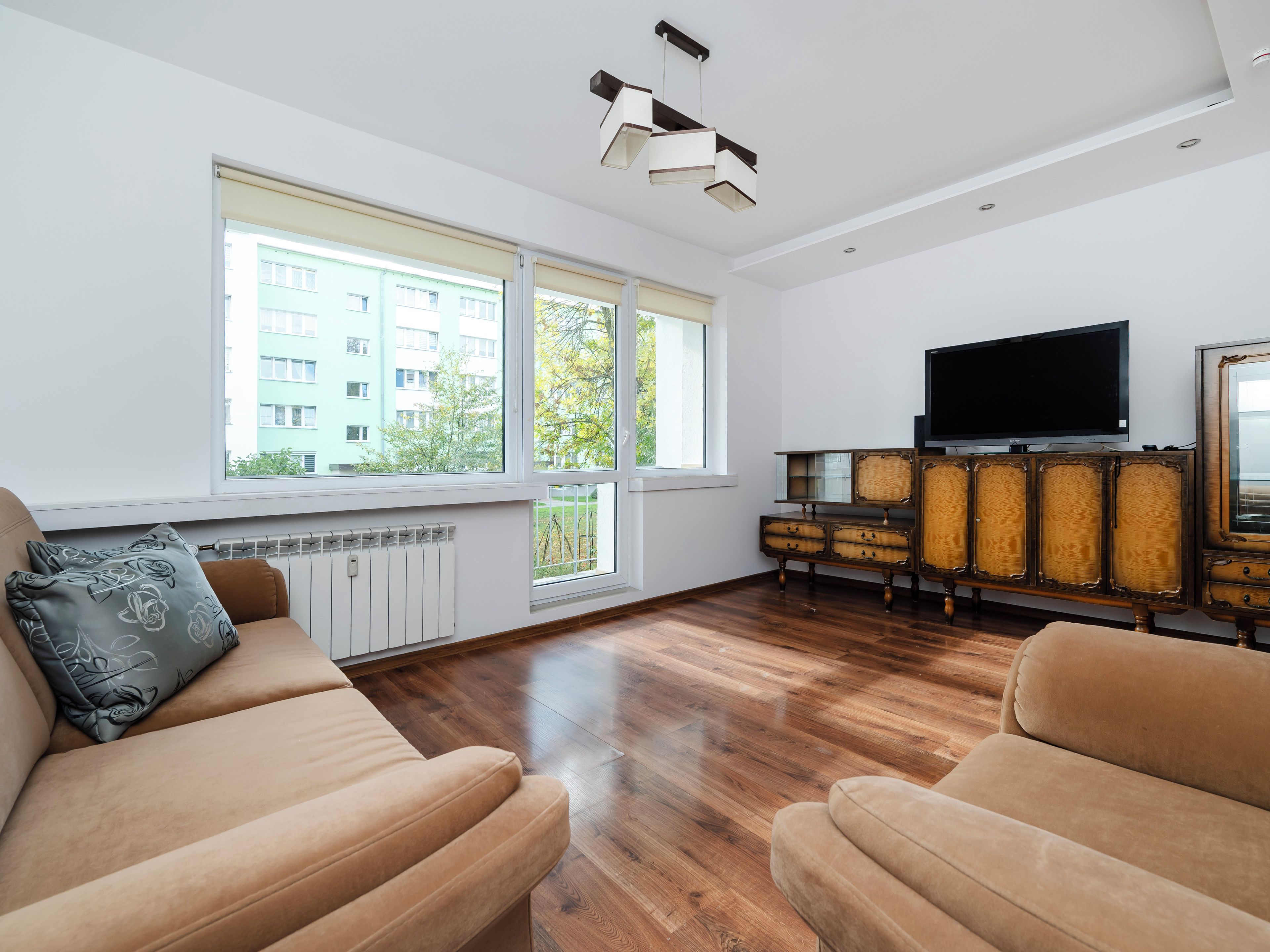 Una sala de estar moderna con un sofá, un televisor y un mueble.
