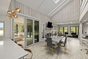 Un espacio habitable amplio con una mesa de comedor, asientos cómodos y ventanas grandes que ofrecen vistas al exterior.