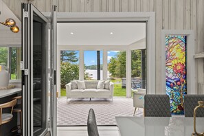 Bright waterfront sunroom with folding doors and beautiful lake views - Lakeshore Retreat-Modern Lakefront Home w/ Hot Tub (Monticello)