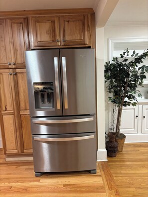 A stainless steel refrigerator with a freezer compartment, set against wooden cabinetry in a kitchen. - Private bathroom + bedroom UNC & Duke Hospital (Durham)