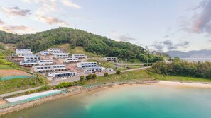 Une zone côtière comprenant un ensemble de bâtiments modernes, une route et une plage.