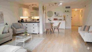 A modern living room with a sofa, coffee table, and a dining area with chairs. - High-quality Condo Type: Studio City & quintessential Los Angeles lifestyle. (Studio City)