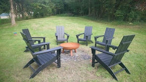 Een ronde zithoek met vier stoelen en een bijzettafeltje.