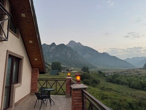 Ein Balkon mit Blick auf Berge, einem Tisch und Stühlen.