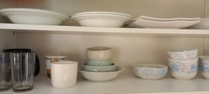 A shelf with various white and floral patterned bowls and mugs. - 3-Min Walk to Camp Humphreys Gate , Private Villa (Pyeongtaek)