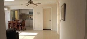 A living room with a ceiling fan, a dining area with chairs and a table, and a kitchen with cabinets and appliances. - 3-Min Walk to Camp Humphreys Gate , Private Villa (Pyeongtaek)