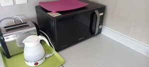 A kitchen with a microwave, toaster, and kettle on a green tray. - 3-Min Walk to Camp Humphreys Gate , Private Villa (Pyeongtaek)