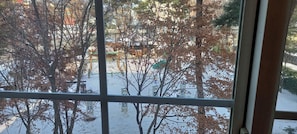 A view through a window with bare trees and a snow-covered ground. - 3-Min Walk to Camp Humphreys Gate , Private Villa (Pyeongtaek)