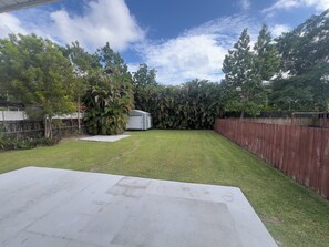 A backyard with a lawn, a shed, and a wooden fence. - The Miami Urban House - Modern Serenity in the Heart of Miami (Miami)