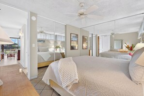 A bedroom with a large bed, a ceiling fan, and a view of the outdoors. - Oceanfront Ground-Floor Retreat at Papakea B108 (Lahaina)