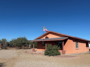 A single-story building with a red exterior and a flagpole with an American flag.