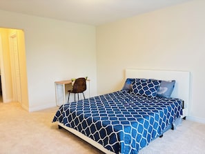 Ein Schlafzimmer mit einem Bett, einem Schreibtisch und einem Stuhl.