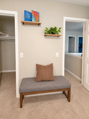 A hallway with a bench, two shelves with books, and a potted plant. - Cedar Park Oasis - Pool, Movie & Game Room, BBQ, Sleeps 18 (Cedar Park)