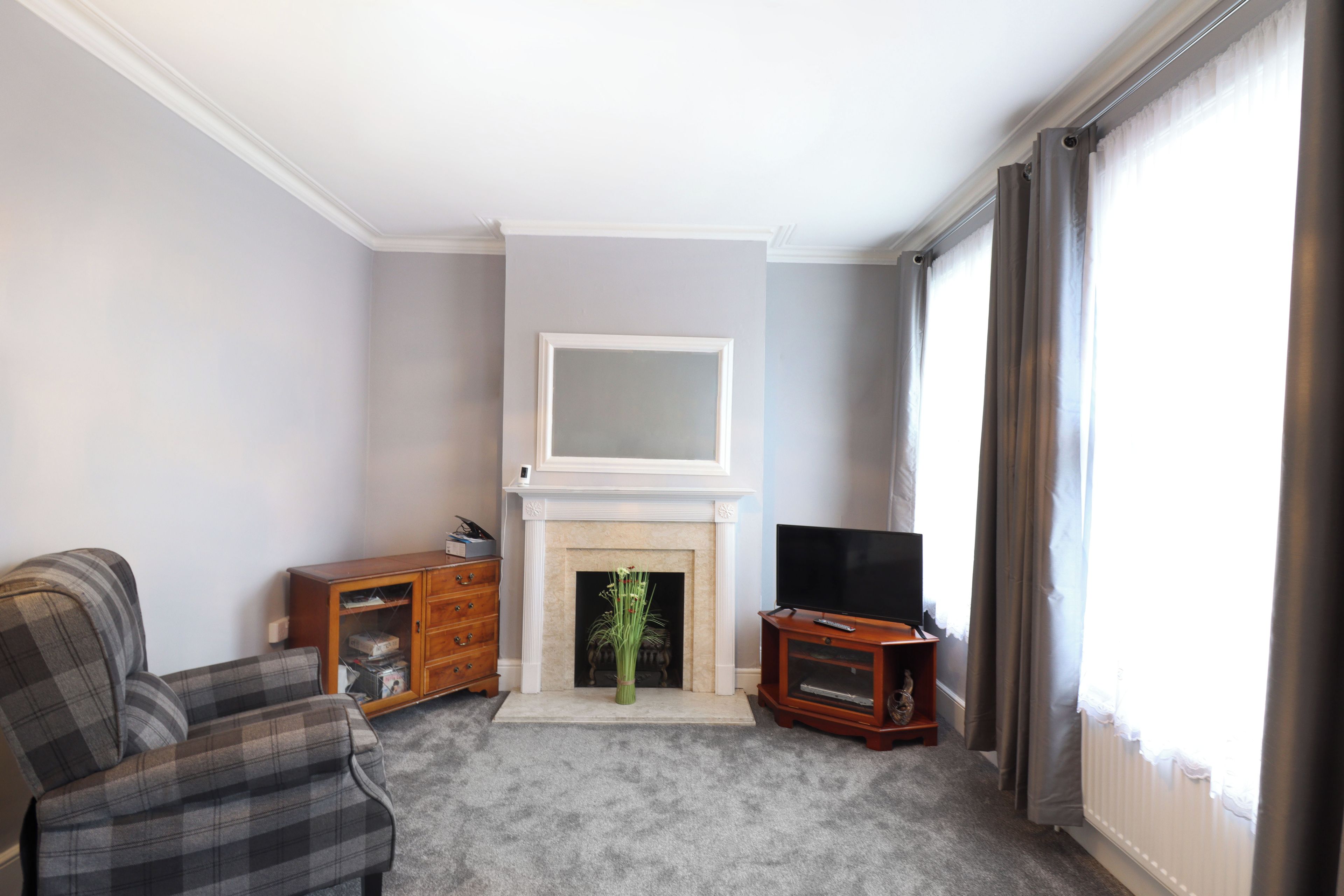 A living room with a fireplace, a television, and a sofa.