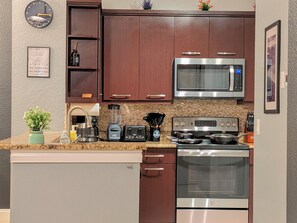 Una cocina moderna con electrodomésticos de acero inoxidable, armarios de madera y encimera de granito.
