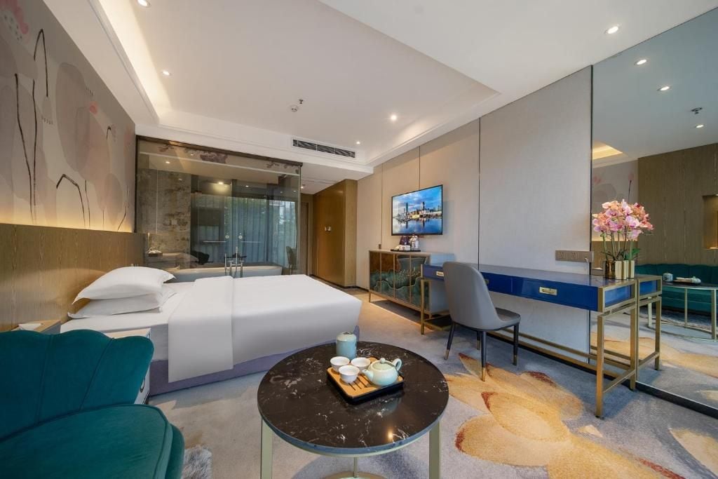 Habitació d'hotel moderna amb llit, escriptori i zona de seients.
