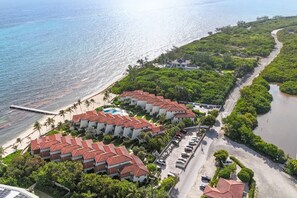 A resort with multiple buildings, a swimming pool, and a beach.