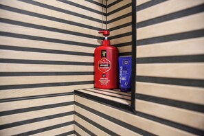 A bottle of Old Spice body wash and a bottle of Blackhead scrub in a corner with striped wall design. - Terrific 3-bedroom apartment in the heart of Pamplona (Pamplona)