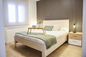 A modern bedroom with a bed, bedside table, lamp, and a window. - Terrific 3-bedroom apartment in the heart of Pamplona (Pamplona)