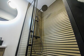 A corner of a room with a shower enclosure, a curved light fixture on the ceiling, and a striped wall. - Terrific 3-bedroom apartment in the heart of Pamplona (Pamplona)