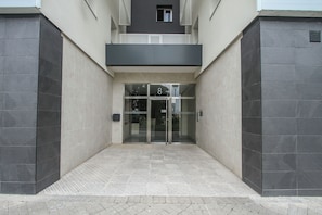 A building entrance with a glass door, a number '8' sign, and a tiled floor. - Terrific 3-bedroom apartment in the heart of Pamplona (Pamplona)
