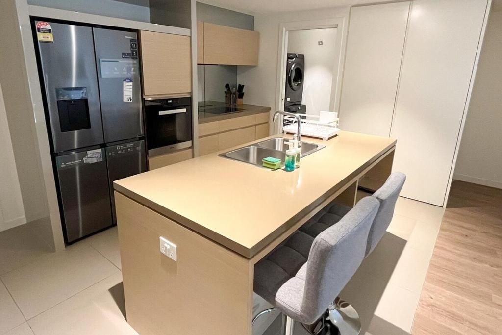 A compact kitchen with a built-in refrigerator, oven, and sink.
