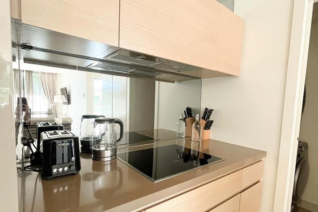 A modern kitchen with a black induction cooktop, two toasters, a kettle, and a knife block.