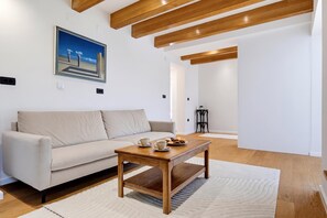 A modern living room with a sofa, coffee table, and a painting on the wall. - Green Zone Apartment With Terrace And Parking, Zagreb, Croatia (Zagreb)