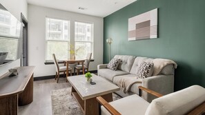 Ein modernes Wohnzimmer mit Sofa, Couchtisch und Essbereich.