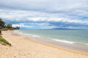 A beach with a sandy shore and calm water. - Oceanfront Kihei Condo | Ground Floor, Pool, Hot Tub & AC (Kihei)