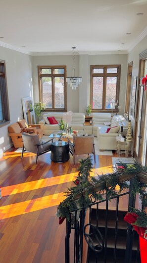 Ein großzügiges Wohnzimmer mit einer großen Sofagarnitur, einem Couchtisch und einer Deckenleuchte.