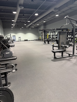 A gym with various exercise equipment, including weight machines and free weights.