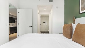 A hotel room with a bed, a bathroom, and a kitchenette. - Landing | Chic 1BD, Pool, Courtyard (Orlando)