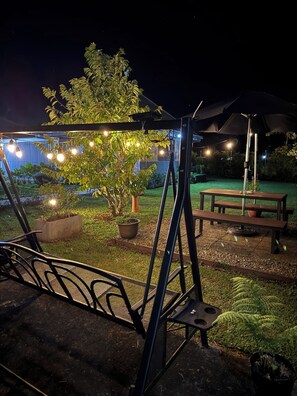 Ein Patio mit Schaukel, Picknicktisch und Lichterkette.