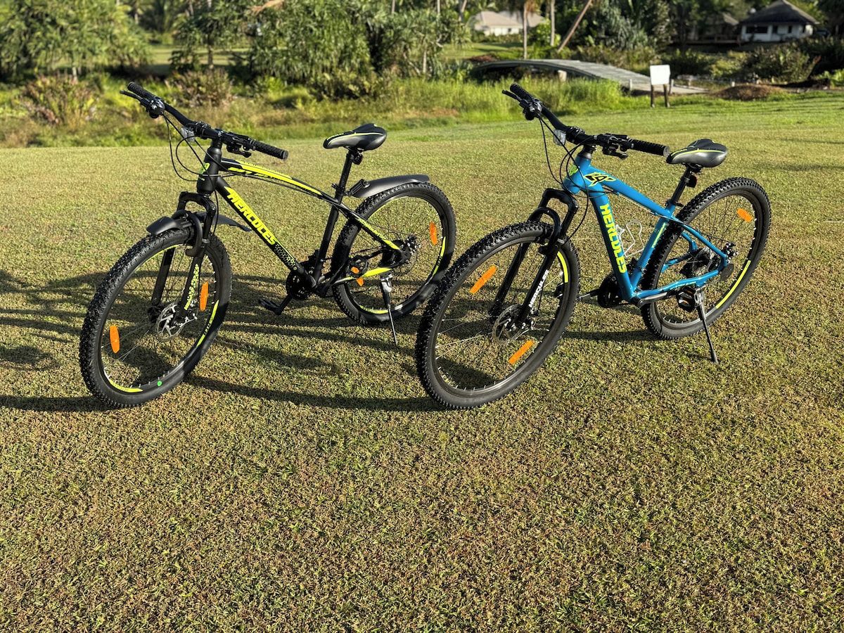 Two bicycles parked on a grassy field.