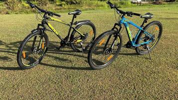Two bicycles parked on a grassy field.